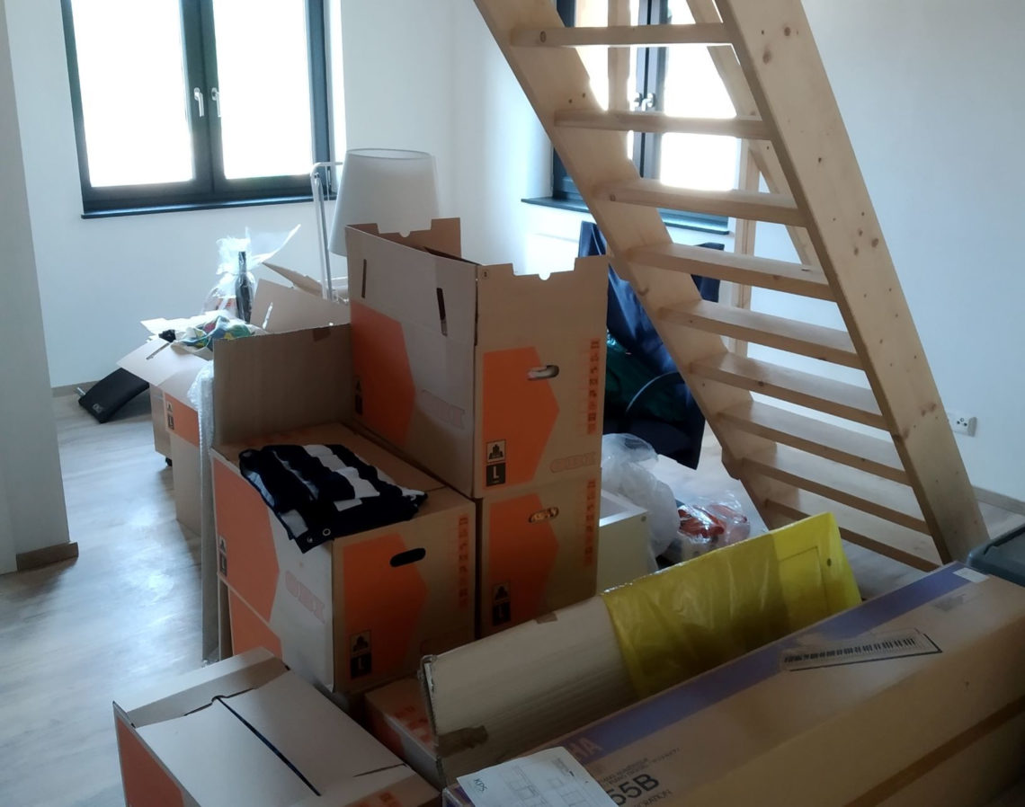 Umzugskartons und Bautreppe in neuer Wohnung