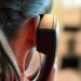 Hinterkopf einer Frau mit Telefonhörer am Ohr
