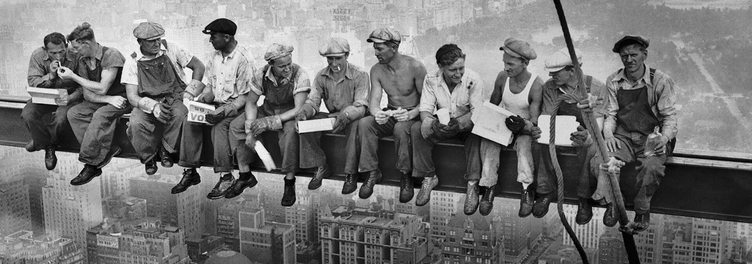 Elf Bauarbeiter sitzen auf einem Stahlträger über Manhattan